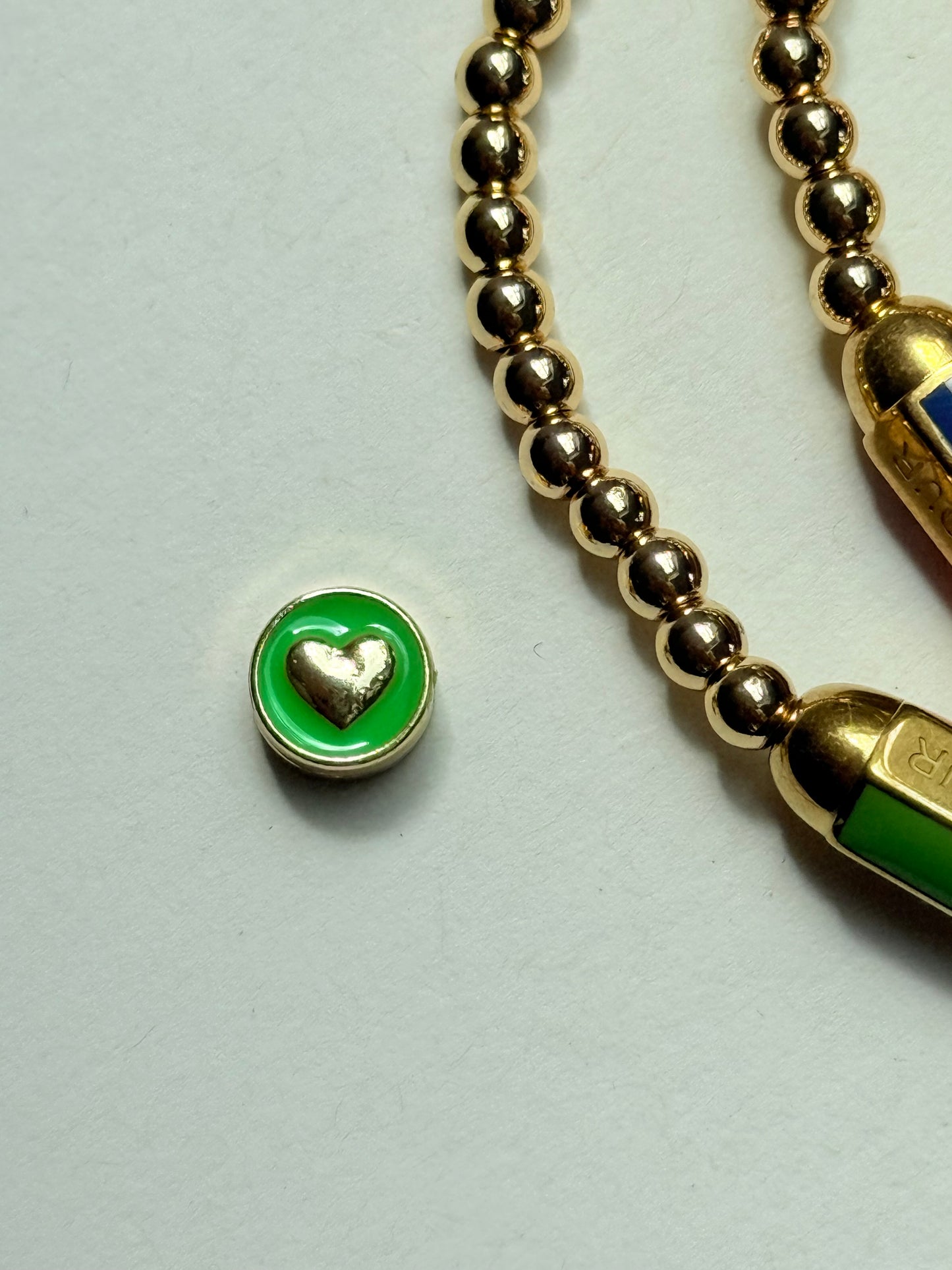 Gold beaded bracelet with charm bead