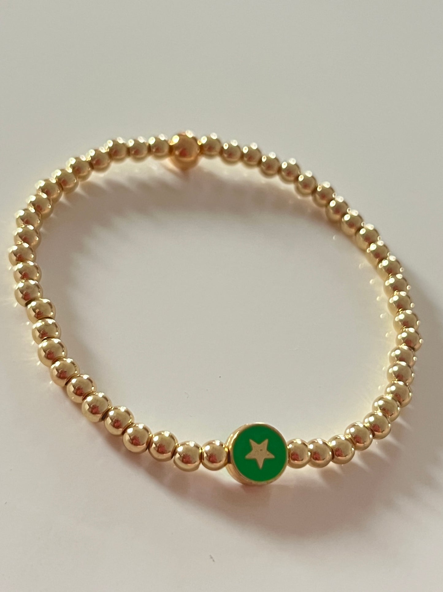 Gold beaded bracelet with charm bead