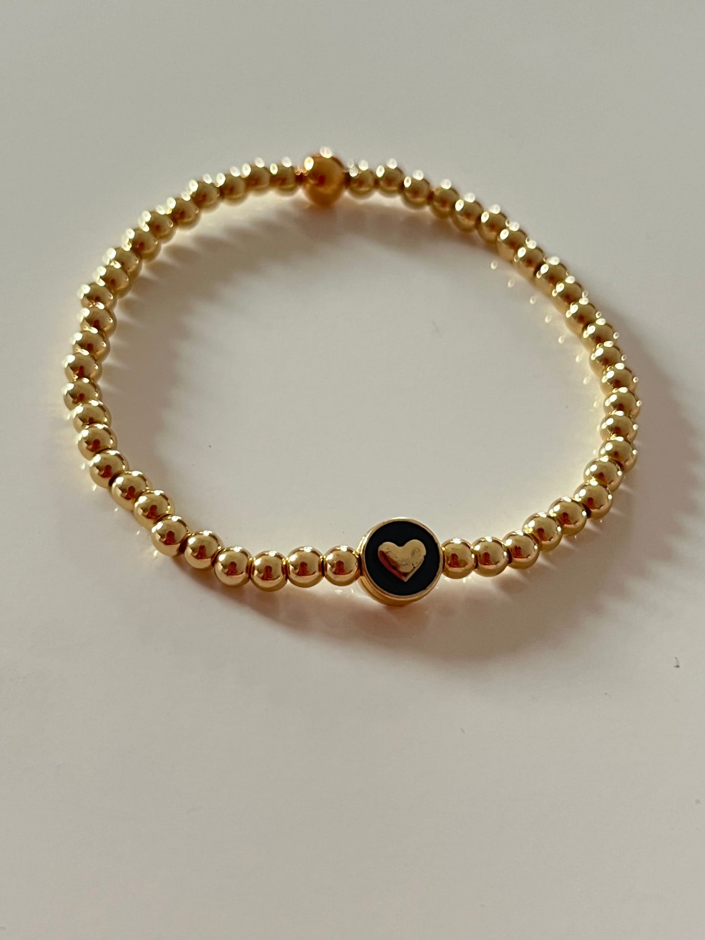 Gold beaded bracelet with charm bead