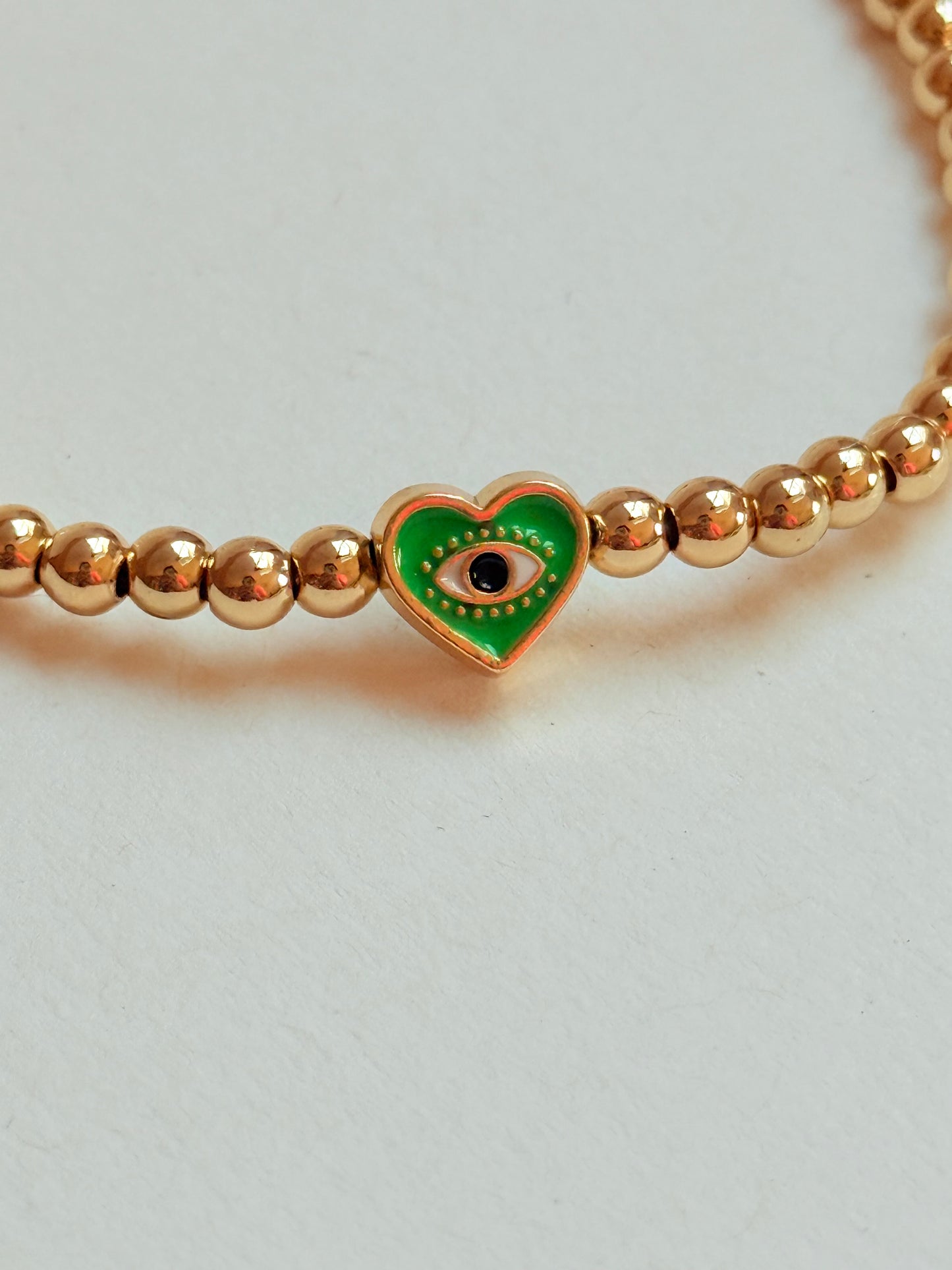 Gold beaded bracelet with charm bead
