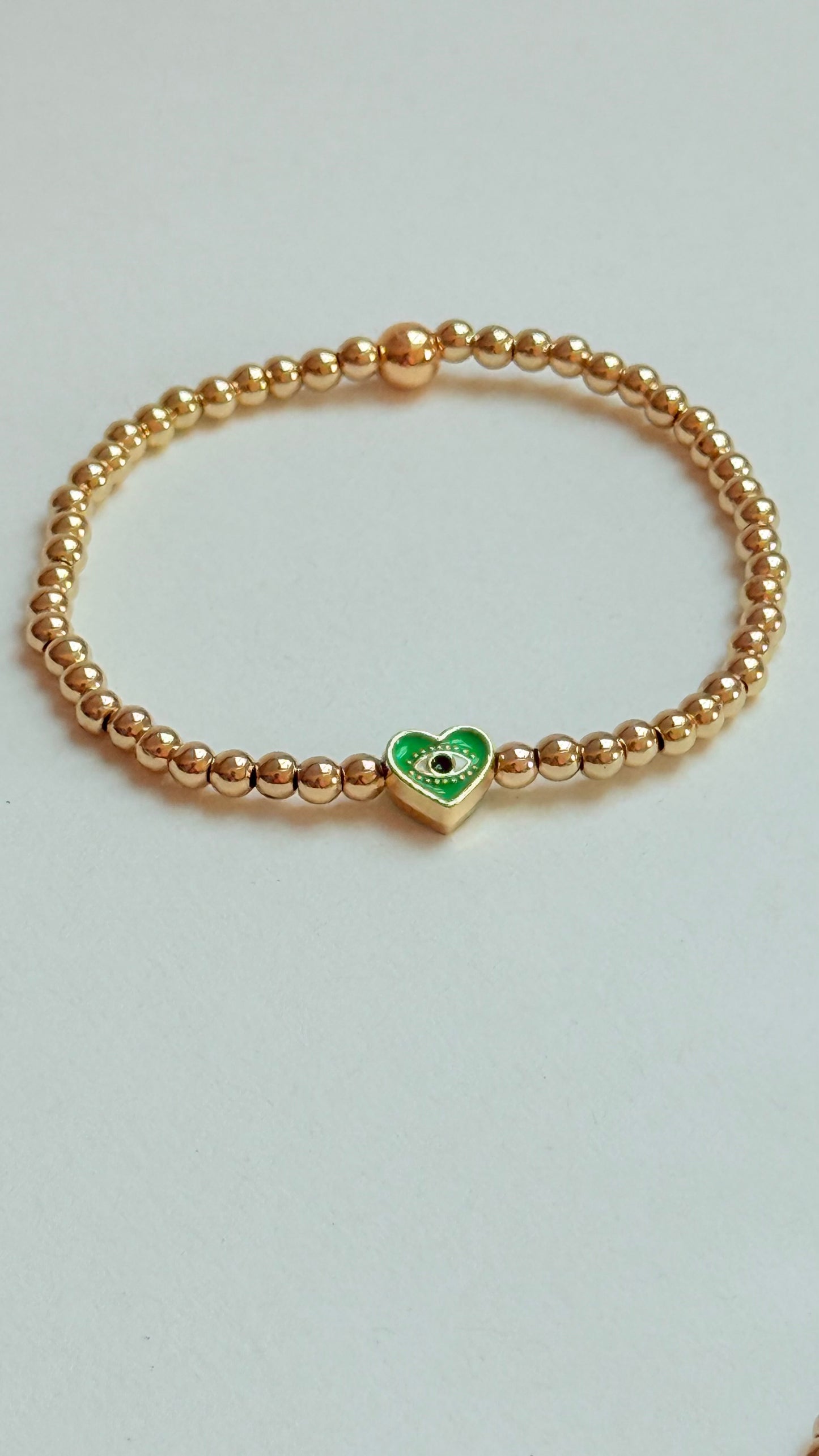 Gold beaded bracelet with charm bead