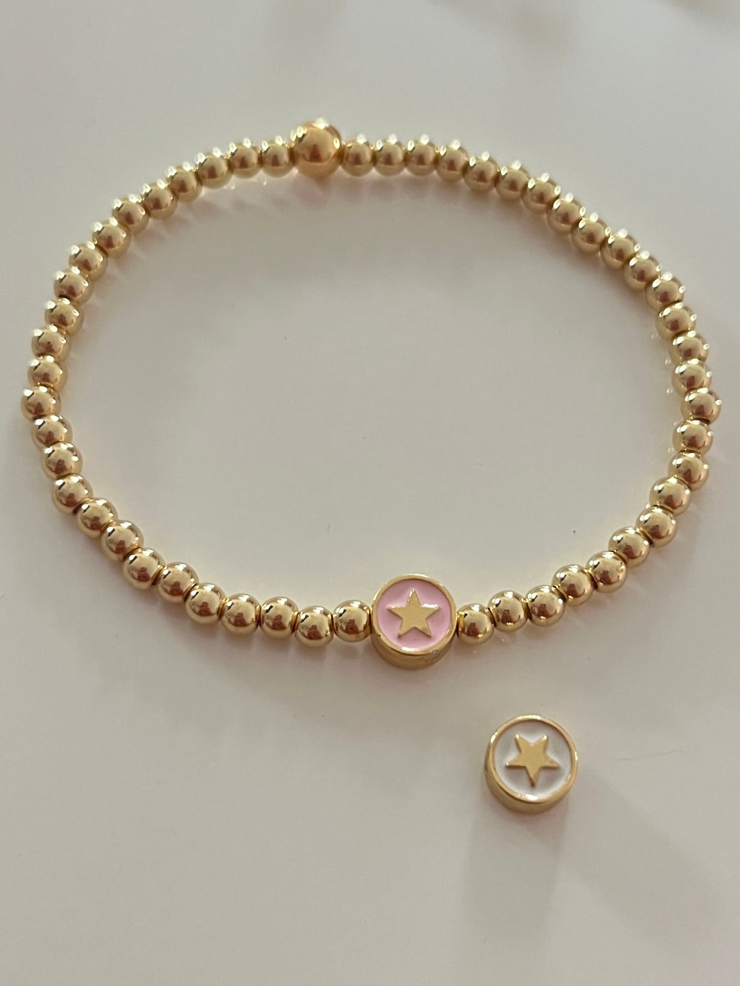 Gold beaded bracelet with charm bead